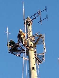 repeaters nh worker on top of tower